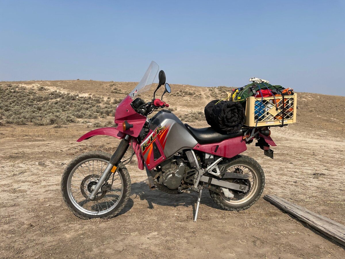A loaded Kawasaki KLR motorcycle in the desert